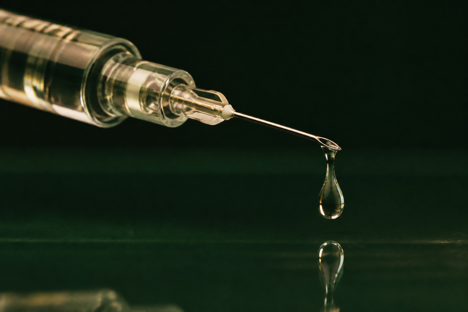 Gota viscosa e transparente na ponta de uma agulha clínica